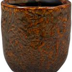 Brown ceramic cup with textured surface on a white background