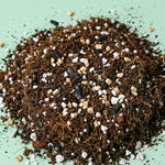 Heap of potting soil soil balanced and designed for calathea with coco coir, vermiculite, activated charcoal and perlite stones on a light green background