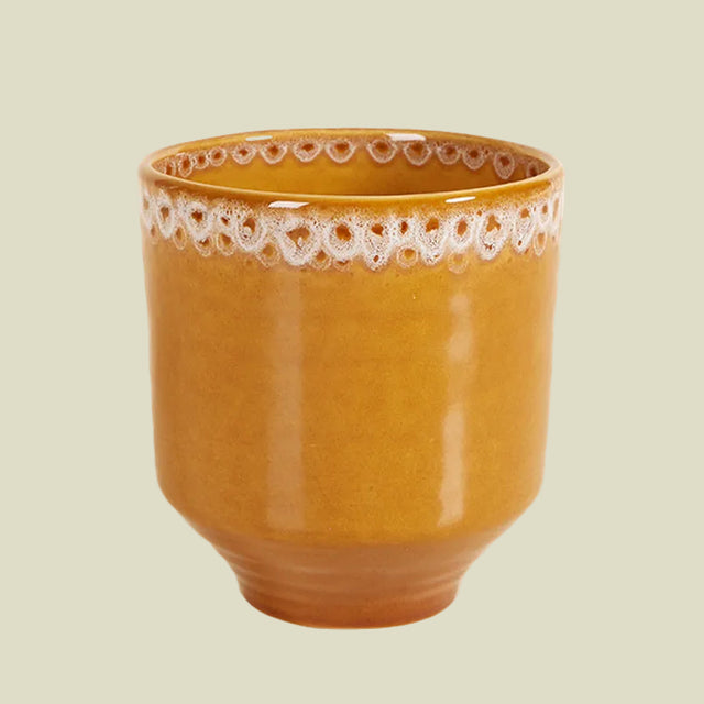 Yellow ceramic houseplant pot with decorative rim on a white background