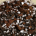 Close-up of a mix of brown and white materials, possibly soil and perlite, on a beige background.